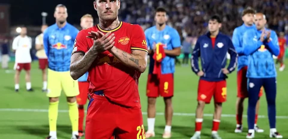 Jugador aplaudiendo con equipo detrás en el campo