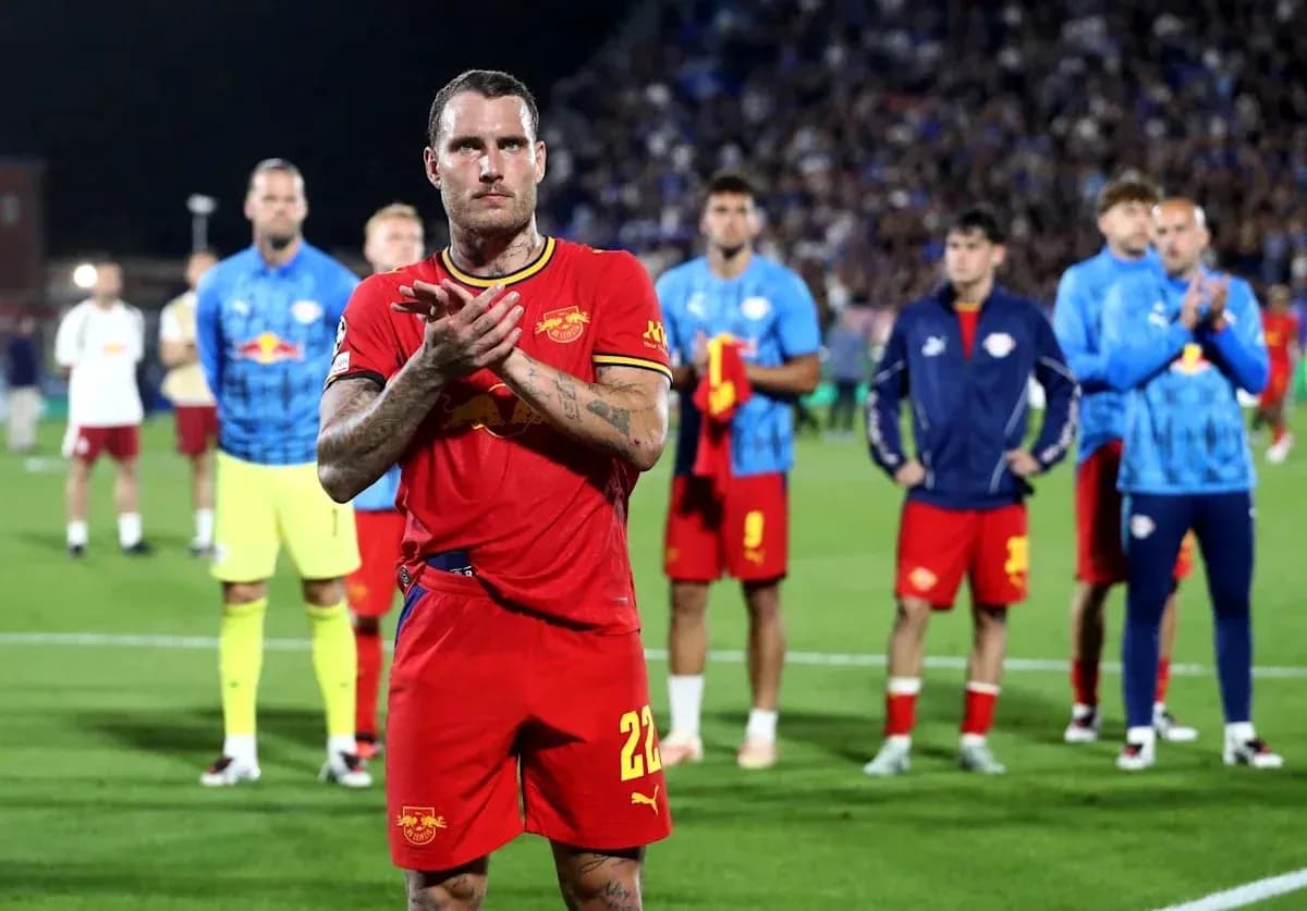 Jugador aplaudiendo con equipo detrás en el campo