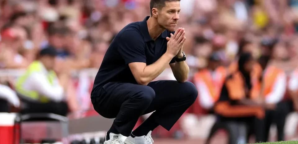 Entrenador agachado en la línea de banda durante el partido