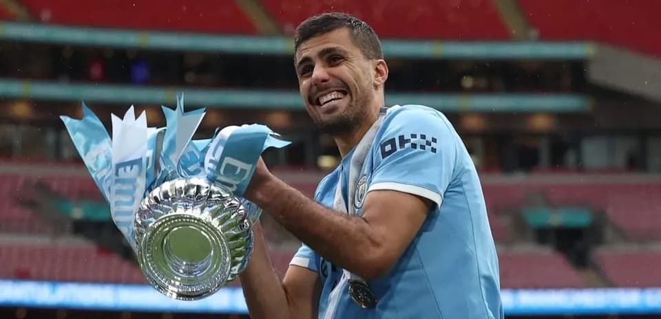 Jugador sosteniendo el trofeo de la copa en Wembley
