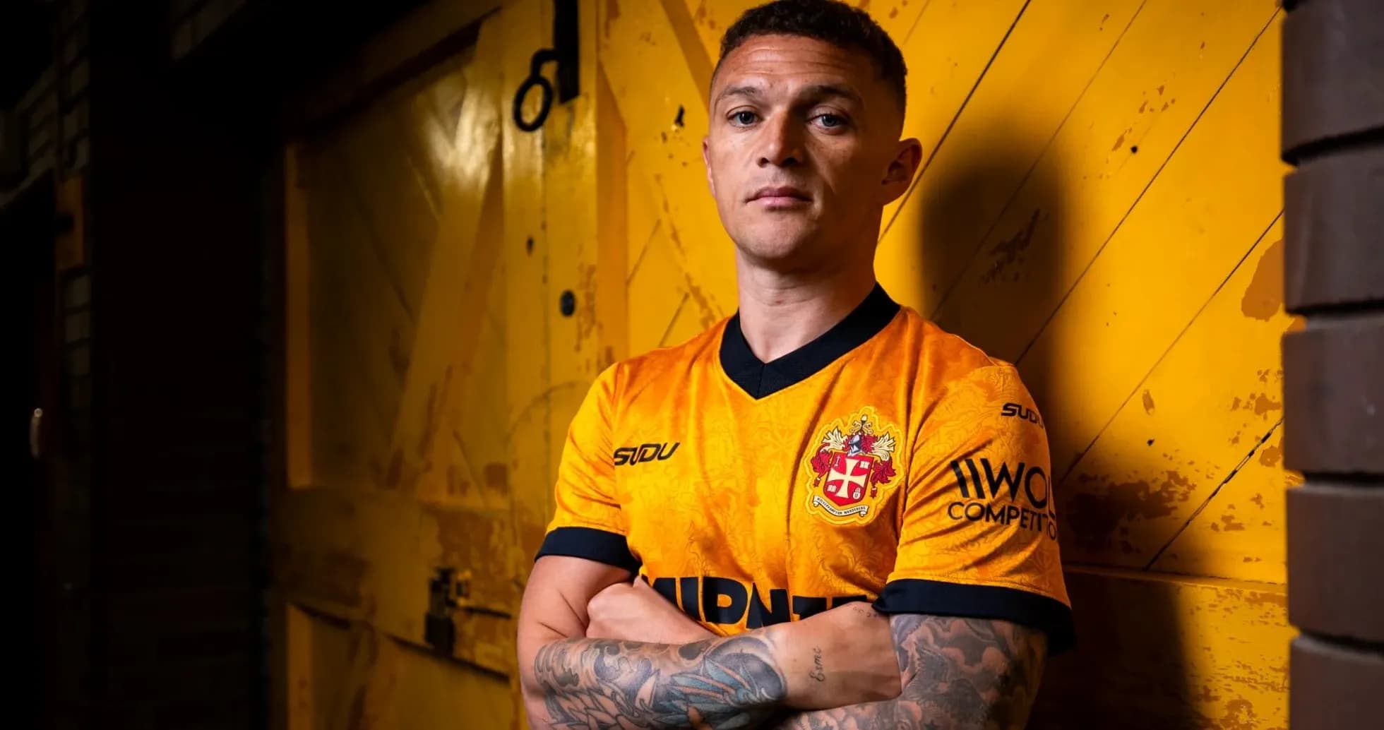 Jugador posando con camiseta en fondo amarillo