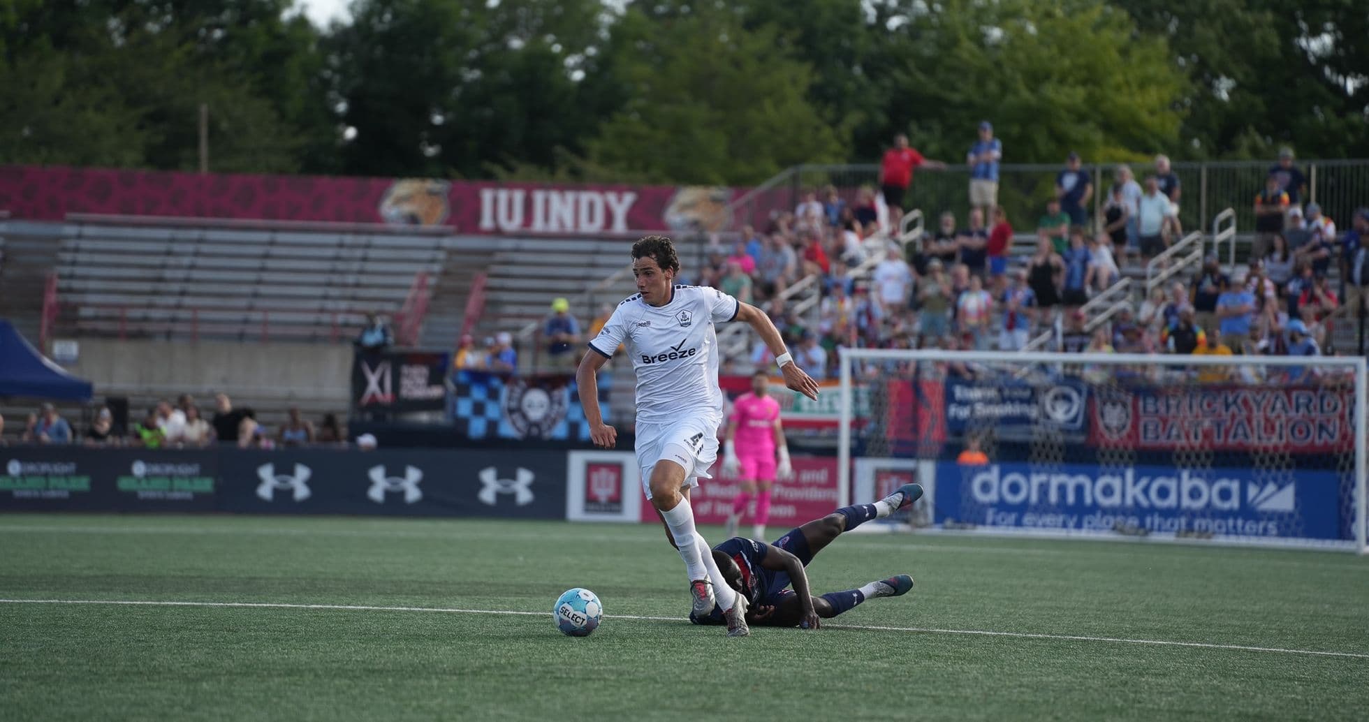 Jugador de Rhode Island esquivando a un oponente