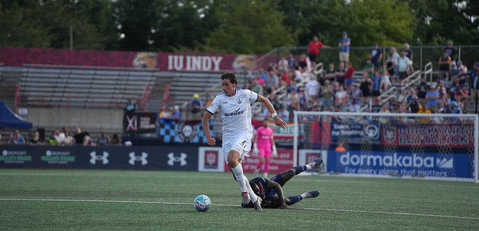 Jugador de Rhode Island esquivando a un oponente