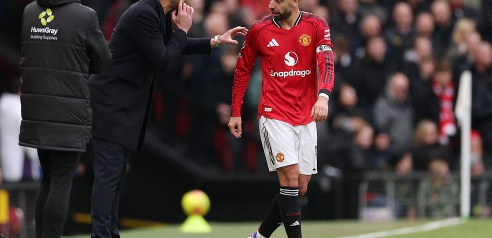 Entrenador dando instrucciones a jugador en el banquillo