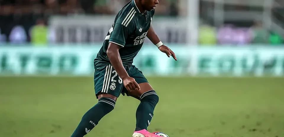 Jugador de Real Madrid driblando el balón en el campo