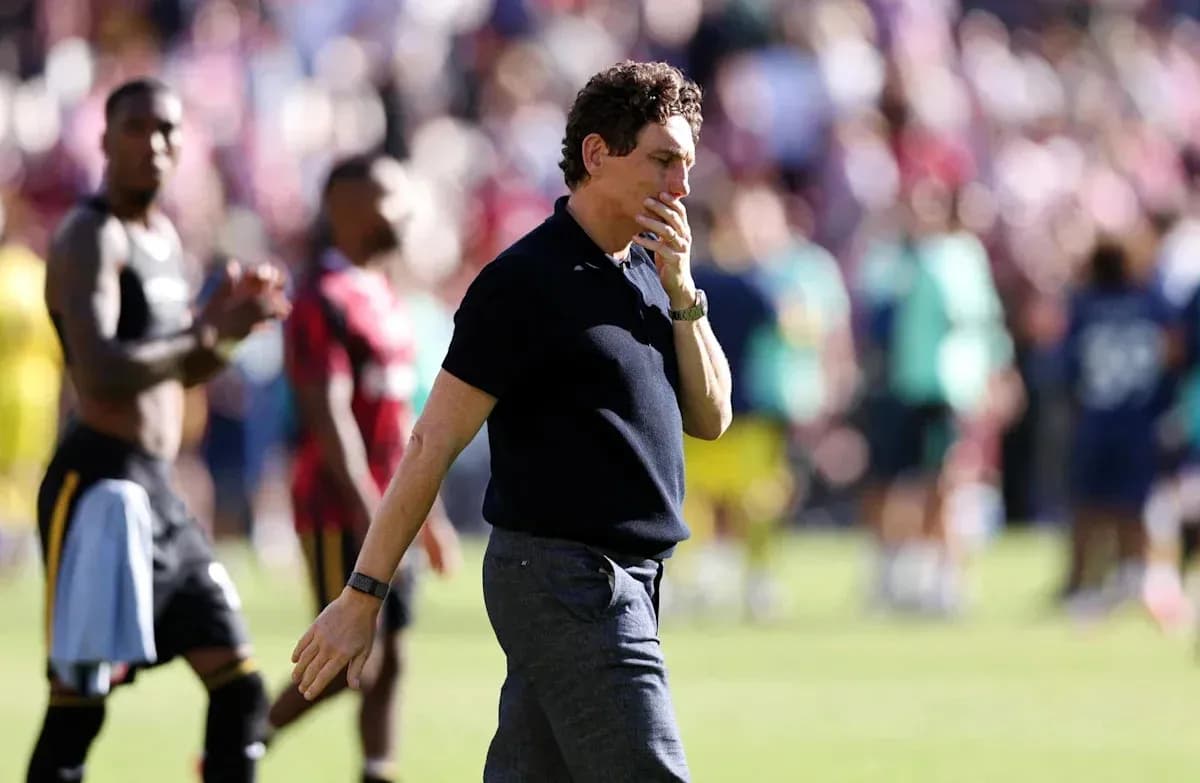 Entrenador caminando tras el partido con jugadores detrás