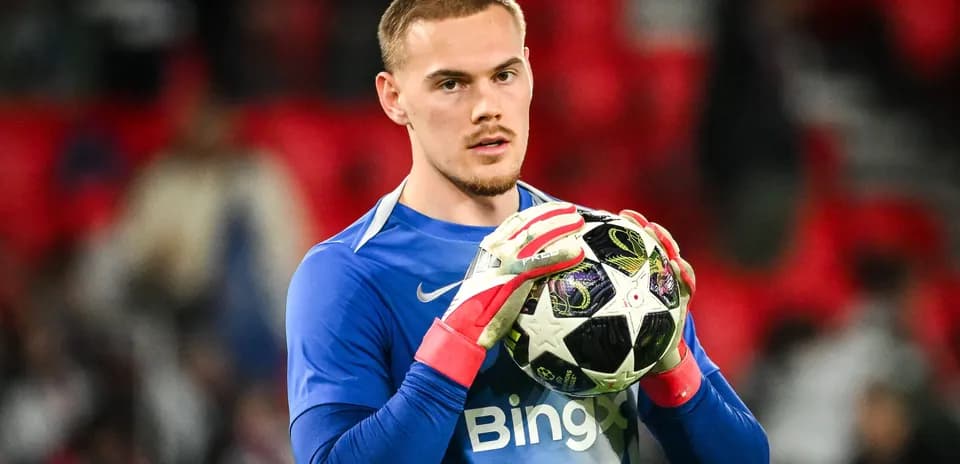 Portero sosteniendo un balón de fútbol en el campo