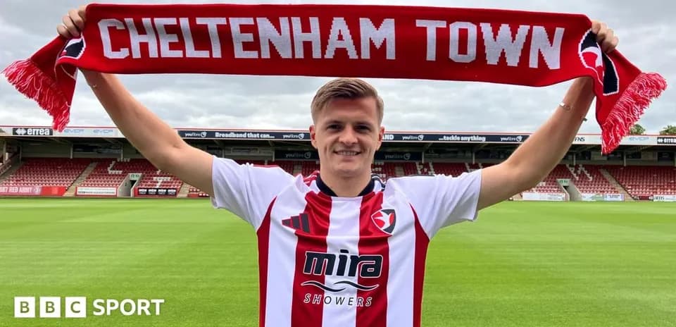 Jugador sostiene una bufanda de Cheltenham Town en el estadio