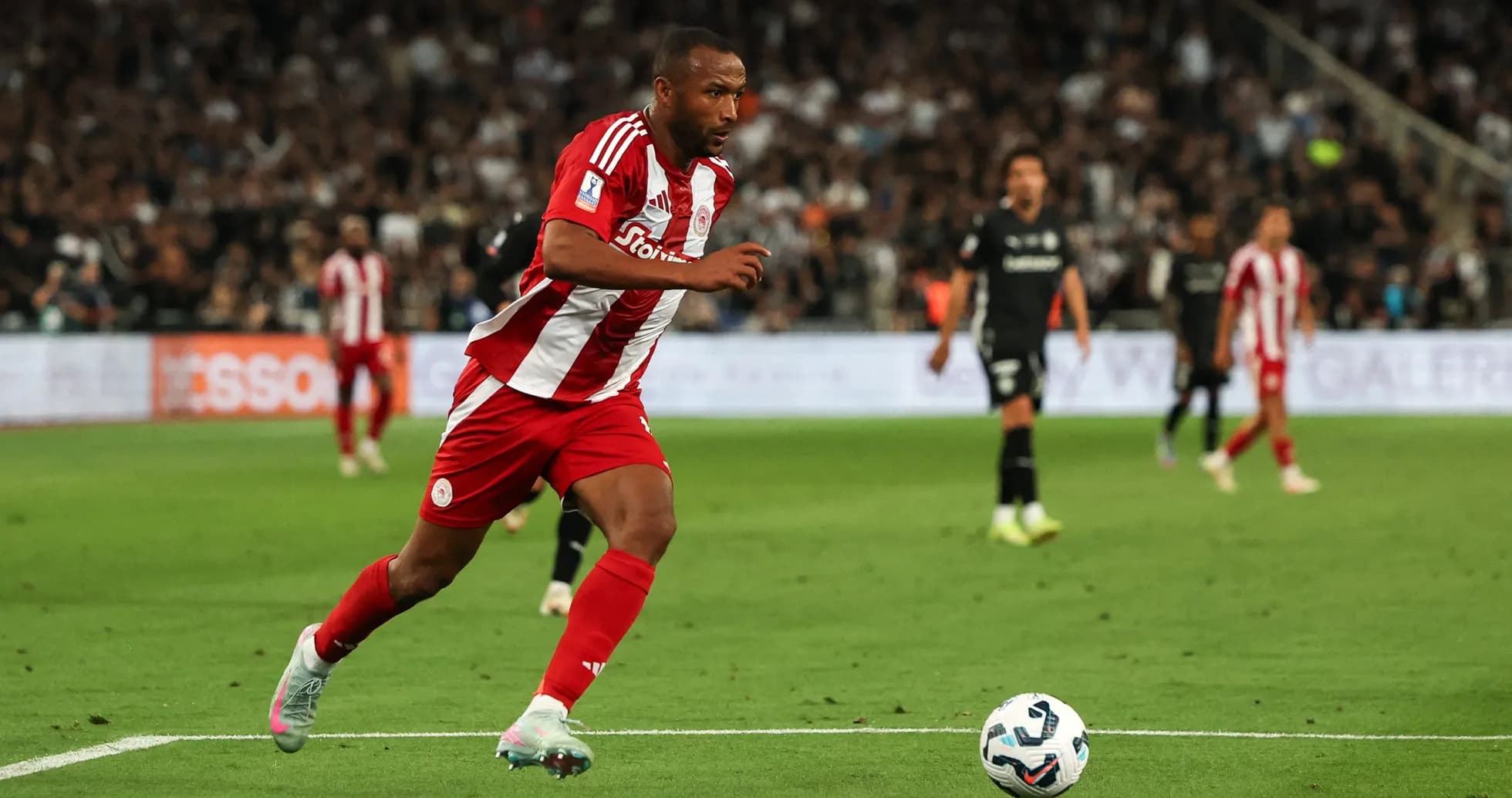 Jugador de Olympiacos corriendo hacia el balón en partido