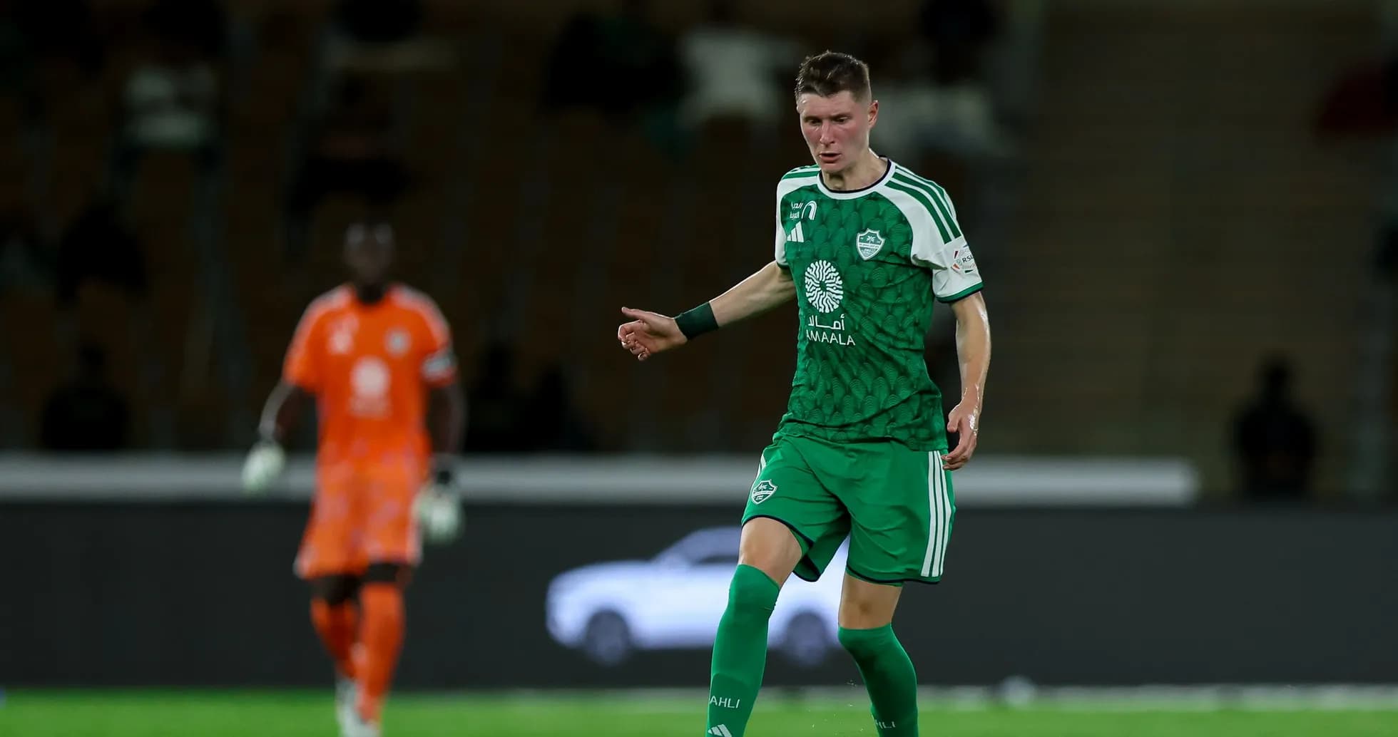Jugador en uniforme verde durante un partido de fútbol