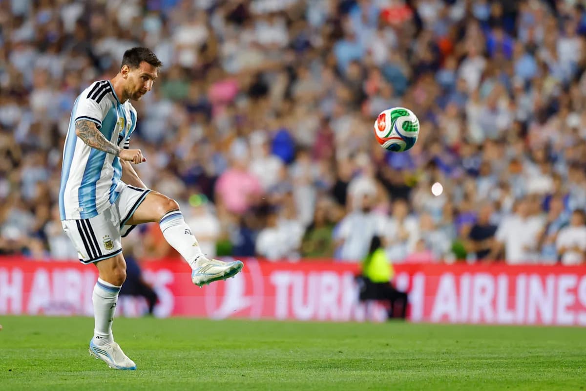 Lionel Messi kicking a soccer ball on the field