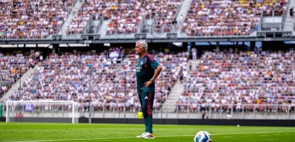 Entrenador observando el partido en estadio lleno