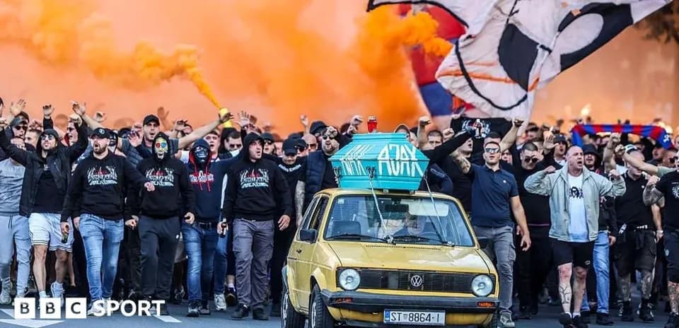 Aficionados marchando con humo naranja y un coche