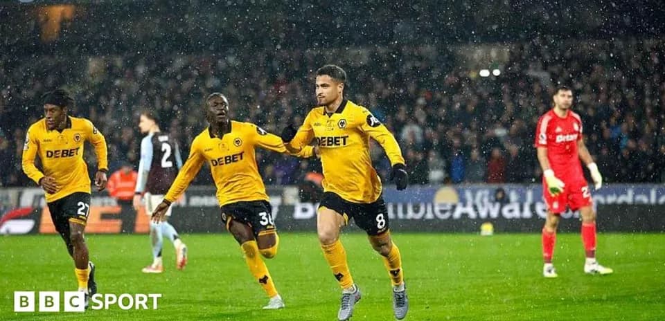 Jugador celebrando gol con compañeros bajo la lluvia