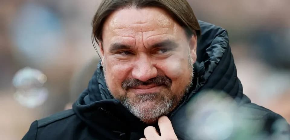 Entrenador sonriendo durante un partido de fútbol
