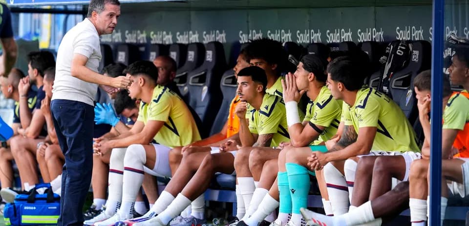 Entrenador hablando con jugadores en el banquillo