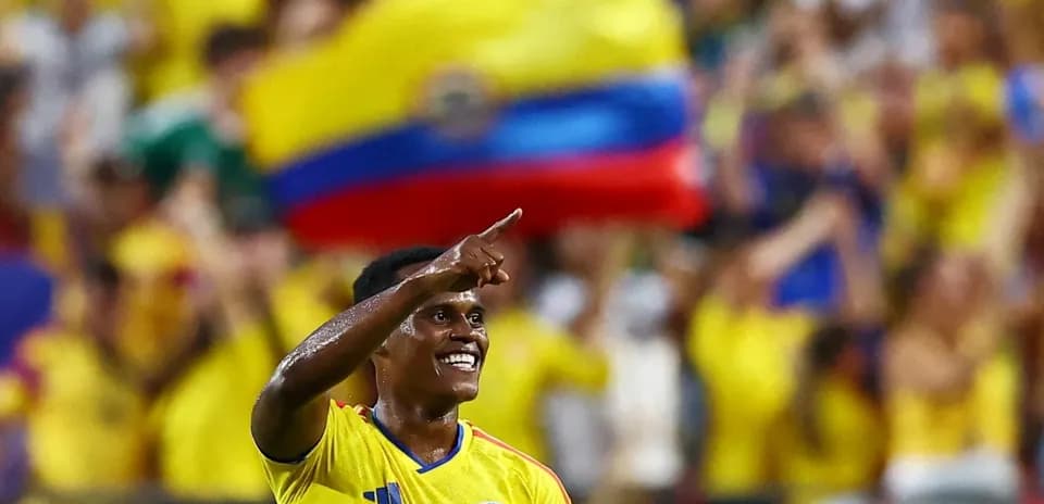Jugador colombiano celebrando con afición durante partido