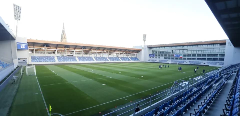 Vista del campo de fútbol con jugadores entrenando
