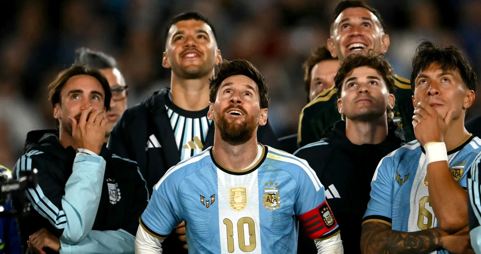 Jugadores de Argentina mirando hacia arriba en el campo