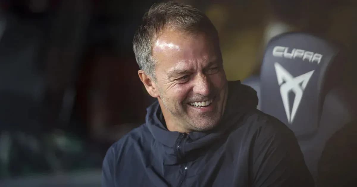 Entrenador sonriendo en el banquillo durante el partido