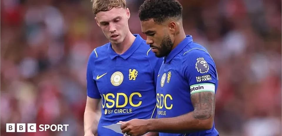Dos jugadores de Chelsea revisando una hoja en el campo