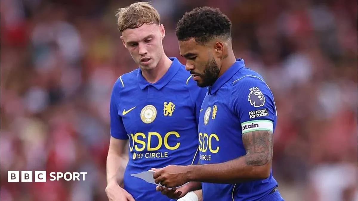 Dos jugadores de Chelsea revisando una hoja en el campo