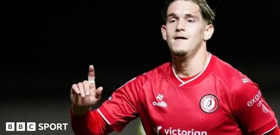 Jugador con camiseta roja señalando al público
