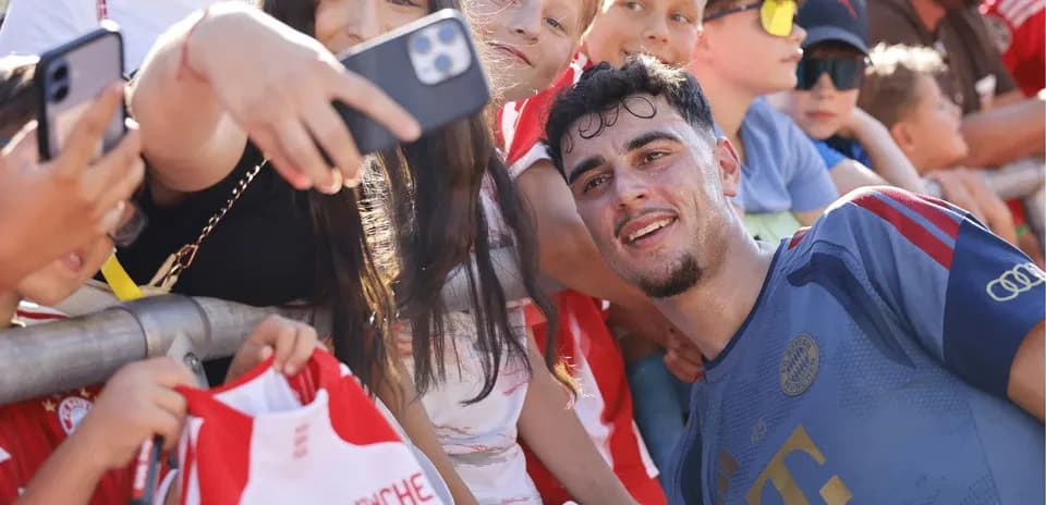 Jugador sonriente posando con fans en evento
