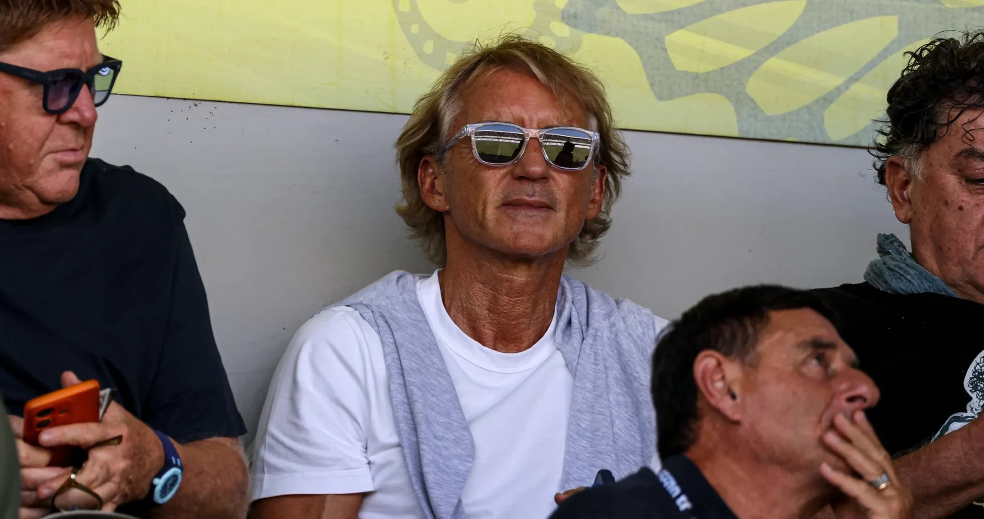 Hombre con gafas sentado en un evento deportivo