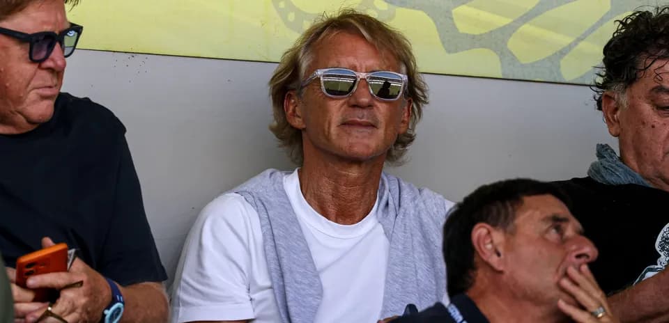Hombre con gafas sentado en un evento deportivo