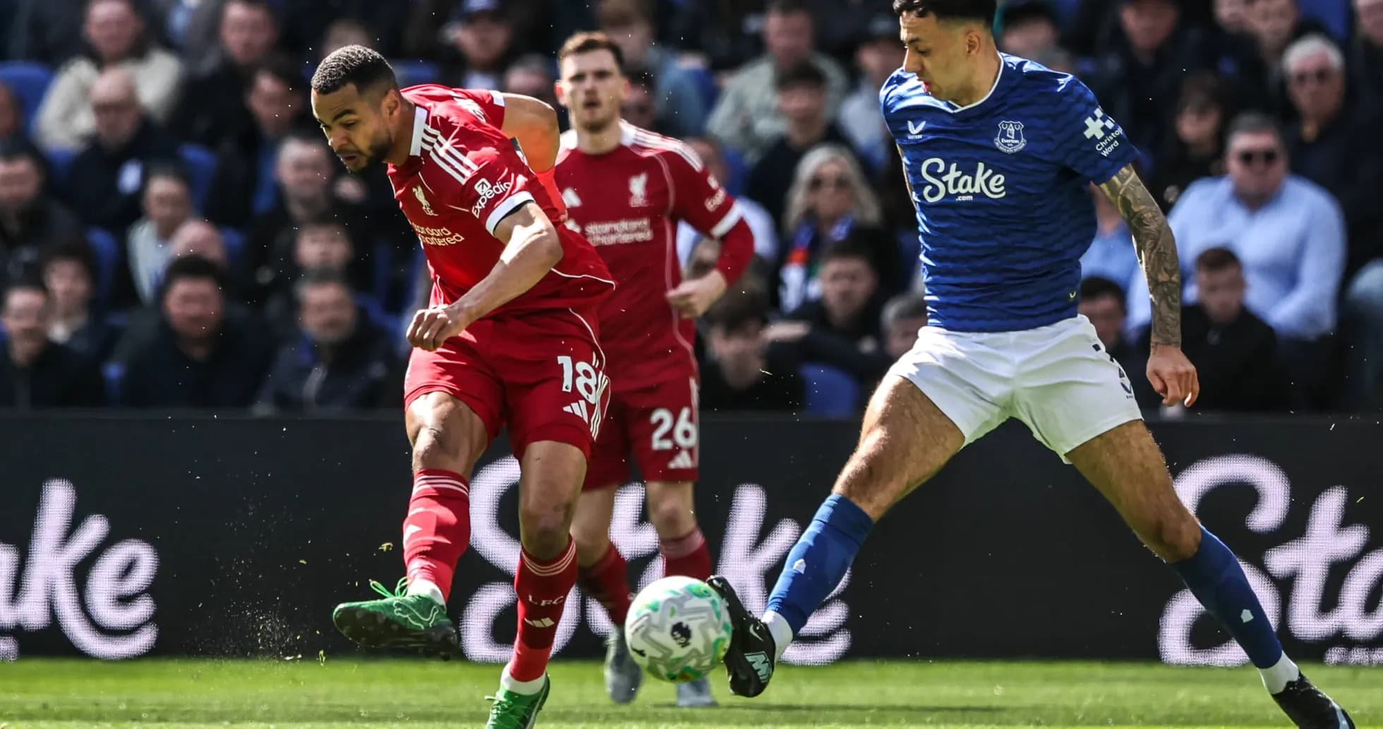 Jugador de Liverpool driblando mientras es presionado por rival