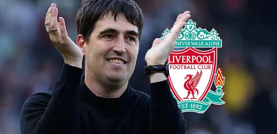 Entrenador aplaudiendo frente al escudo de Liverpool