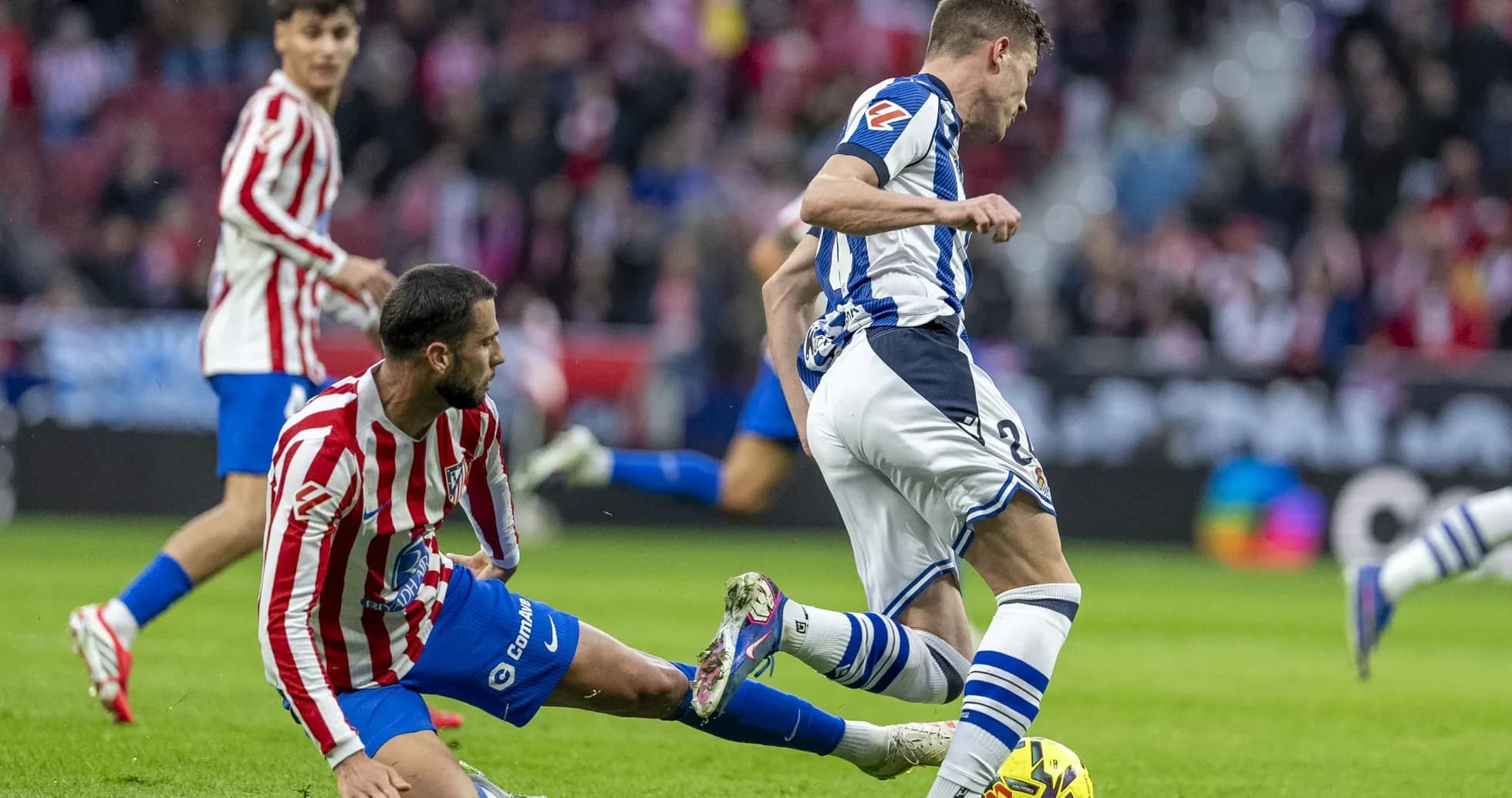 Jugador de Real Sociedad driblando a rival del Atlético