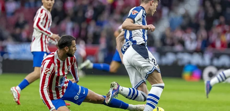Jugador de Real Sociedad driblando a rival del Atlético