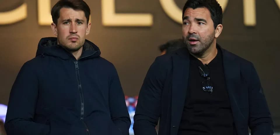 Dos hombres sentados en un evento deportivo