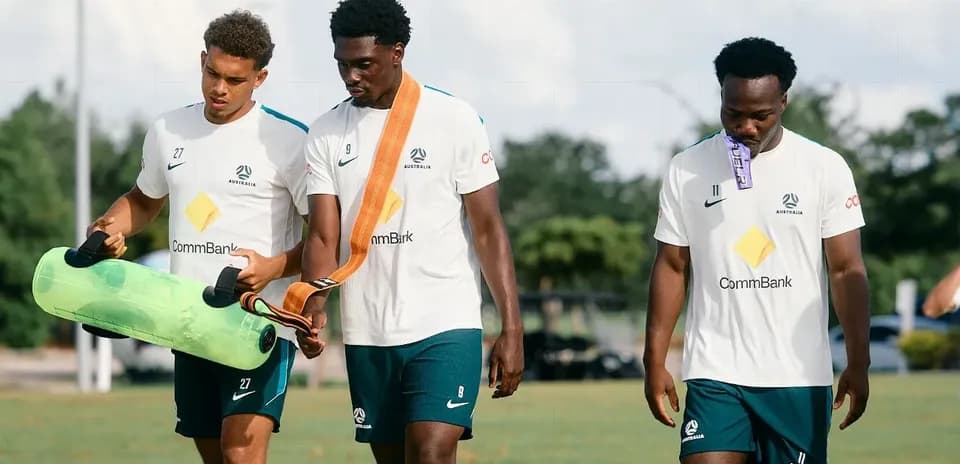 Tres jugadores de fútbol caminando durante entrenamiento