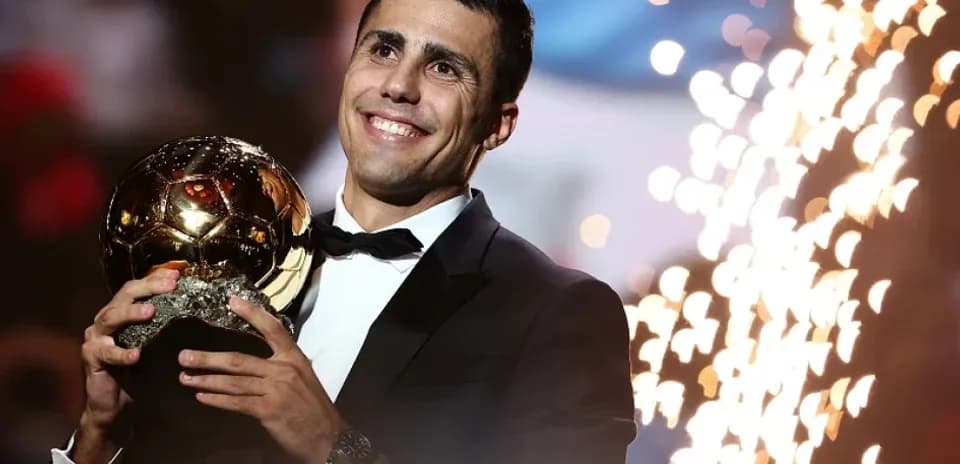 Jugador sosteniendo el Balón de Oro con fuegos artificiales