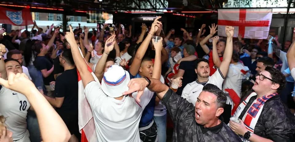Aficionados de Inglaterra animando en un bar