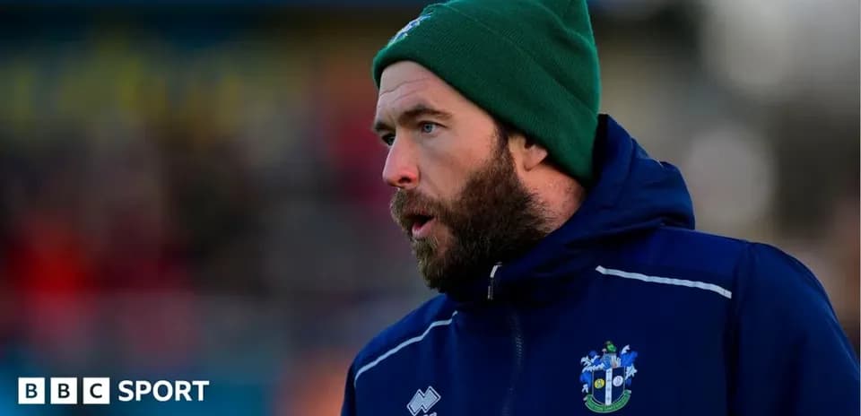 Entrenador con gorro en el campo de fútbol