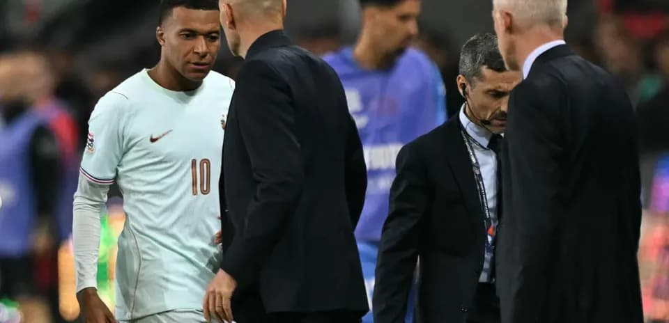 Kylian Mbappé conversando con entrenadores durante el partido