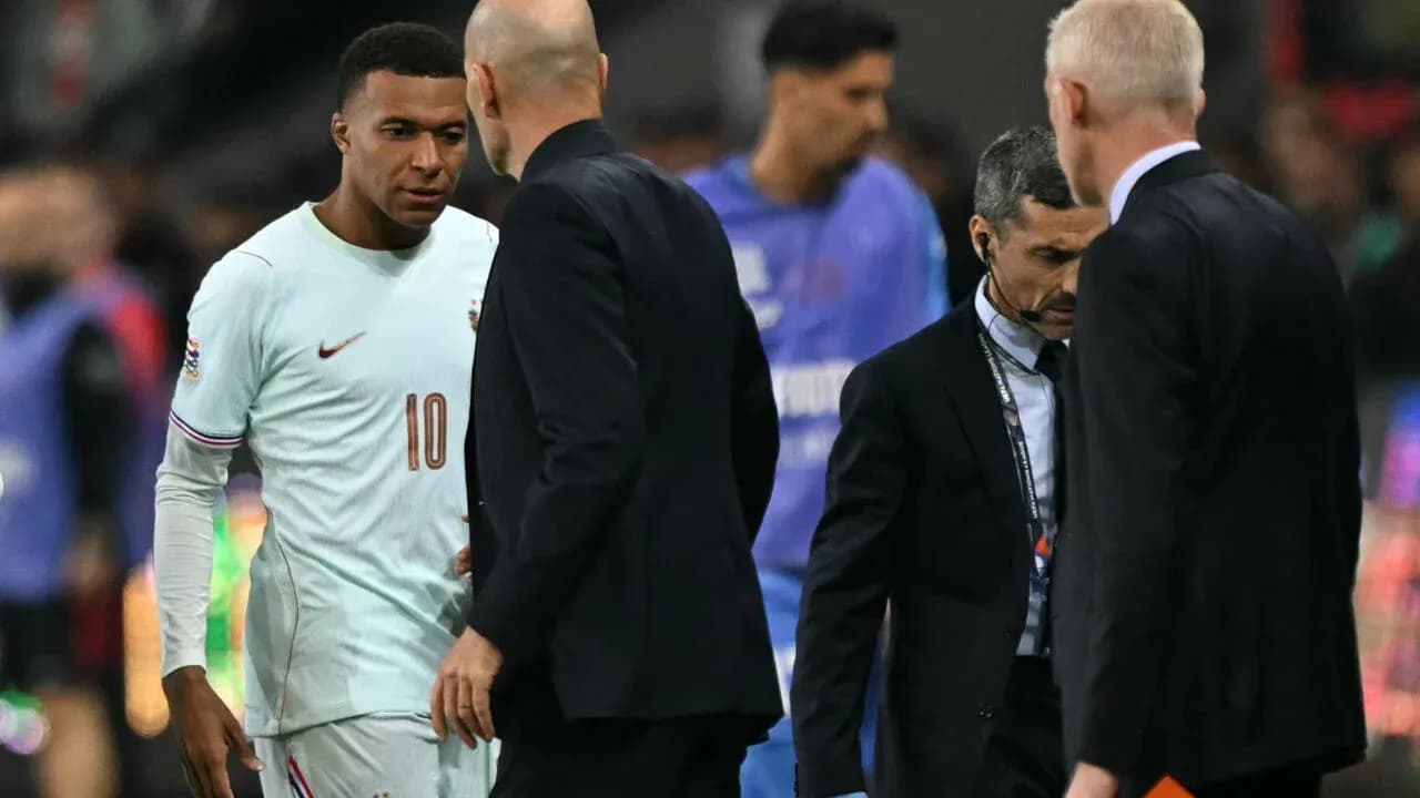 Kylian Mbappé conversando con entrenadores durante el partido