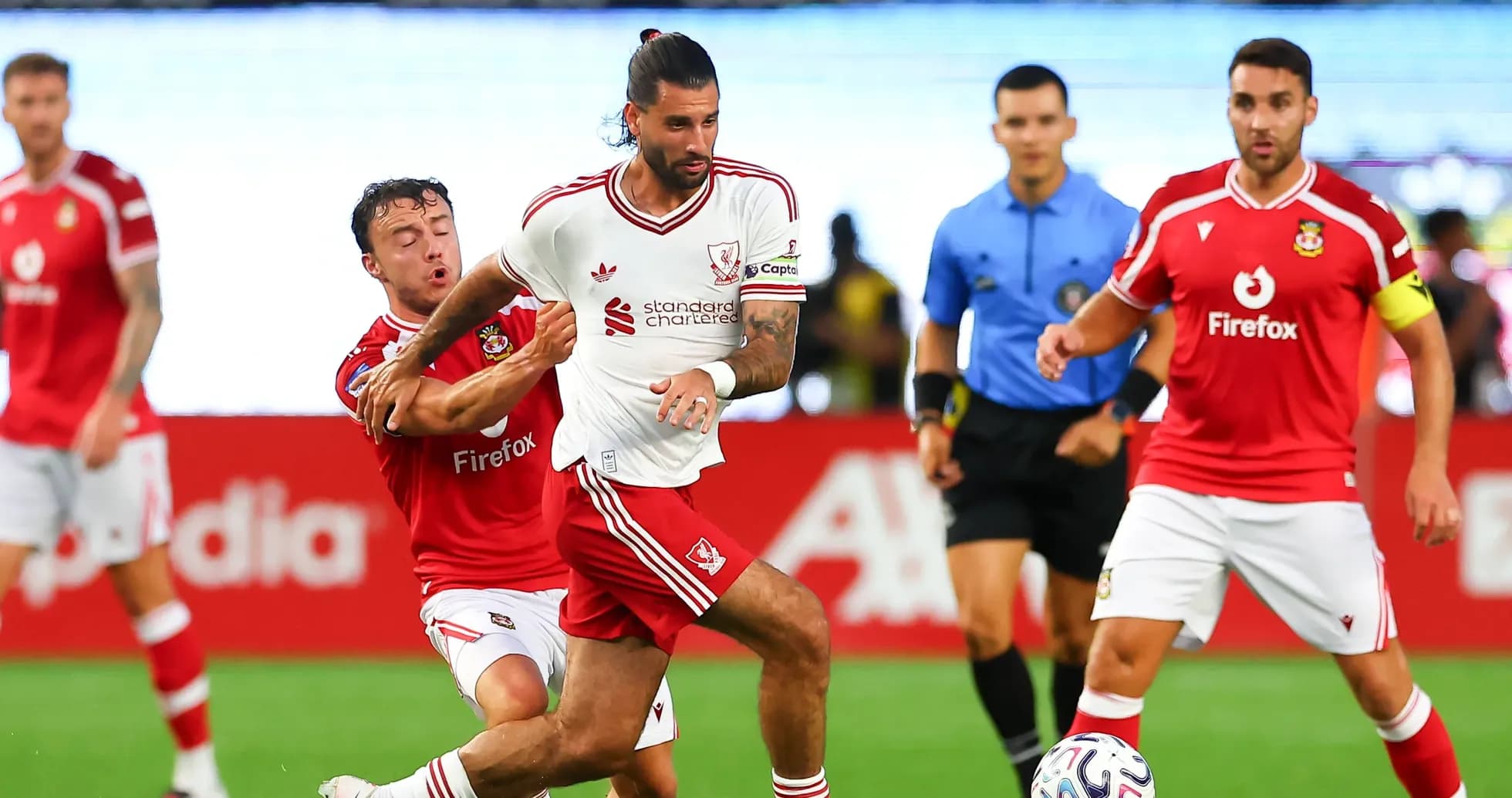 Jugador de Liverpool driblando mientras es marcado