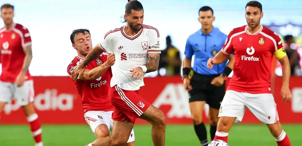 Jugador de Liverpool driblando mientras es marcado