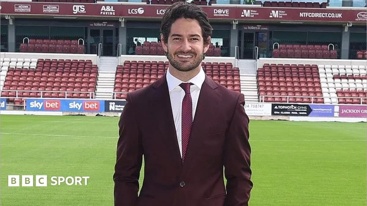 Persona en traje posando en estadio de fútbol
