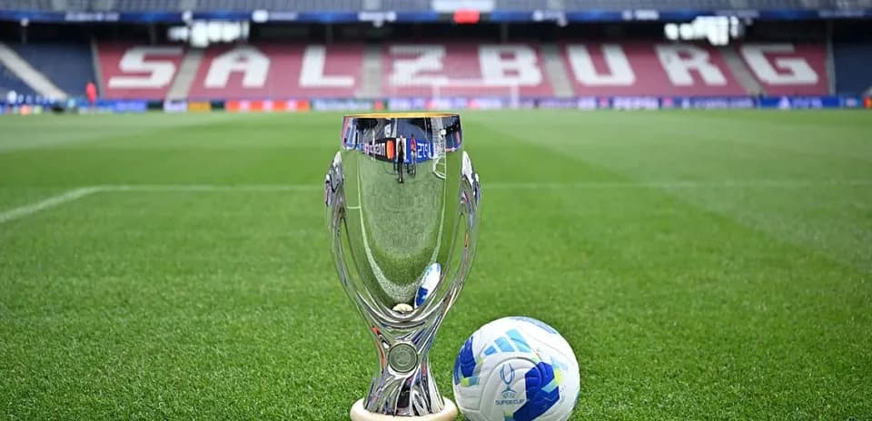 Trofeo y balón de fútbol en campo de juego