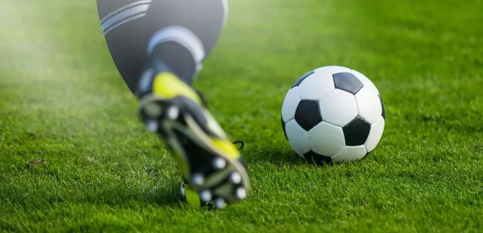 Jugador golpeando un balón de fútbol en el campo