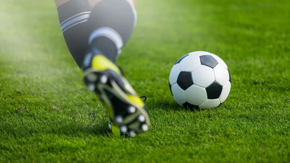 Jugador golpeando un balón de fútbol en el campo