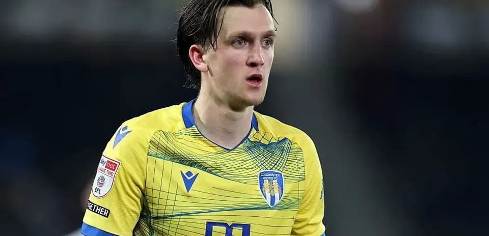 Jugador de Colchester United en uniforme amarillo