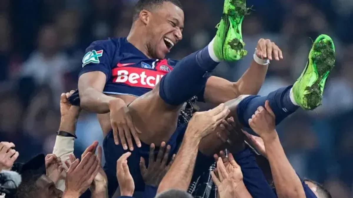 Kylian Mbappé siendo levantado por compañeros de equipo