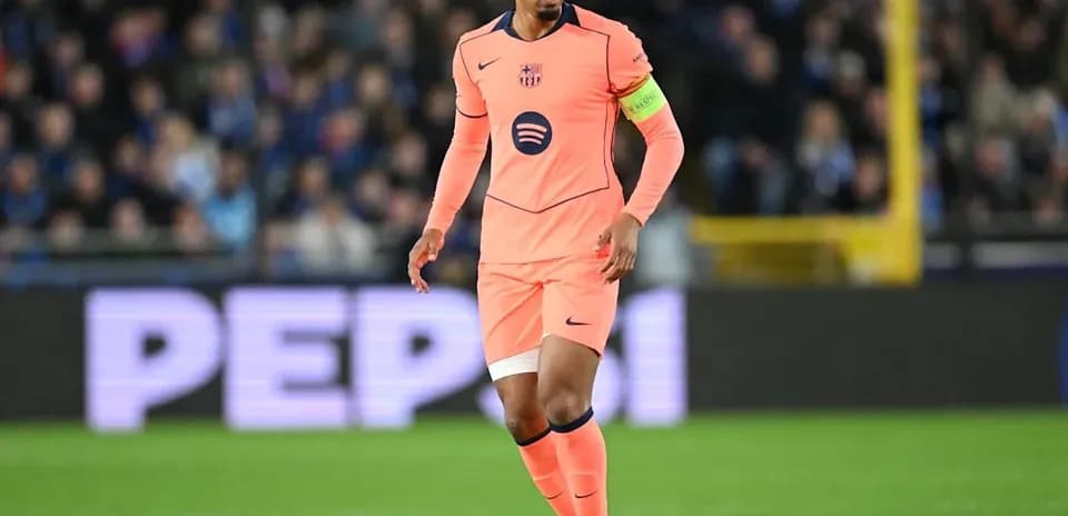 Jugador con camiseta rosa dirigiendo el balón en campo
